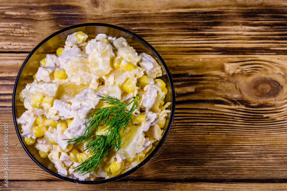 Festive salad with chicken breast, canned pineapple, cheese, sweet corn and mayonnaise on wooden table. Top view Festive salad with chicken breast, canned pineapple, cheese, sweet corn and mayonnaise on wooden table. Top view