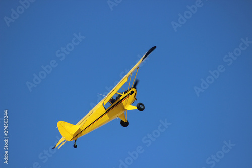 airplane with propeller flying in blue sky 