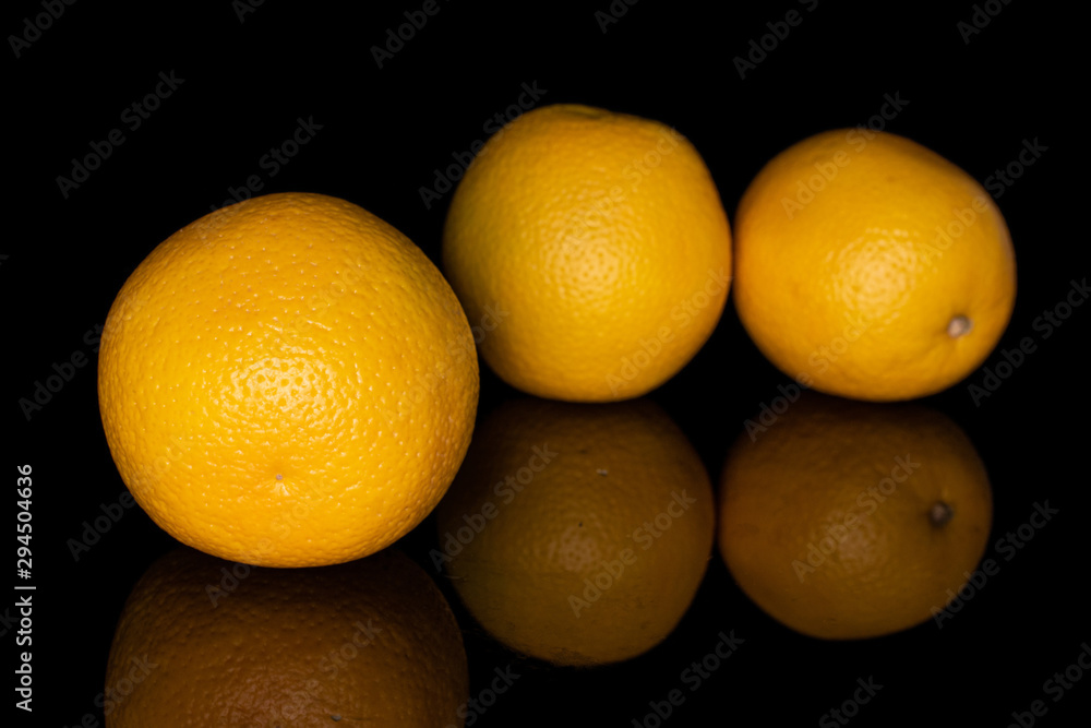 Group of three whole fresh bright orange isolated on black glass Group of three whole fresh bright orange isolated on black glass