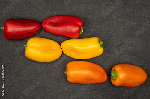 Group of six whole fresh pepper flatlay on grey stone photo