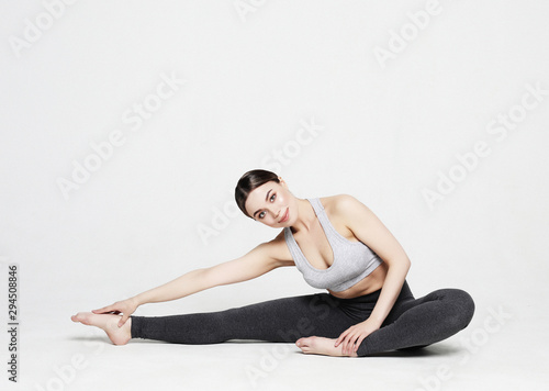 Young woman practicing yoga, working out, wearing sportswear, studio shoot over white background