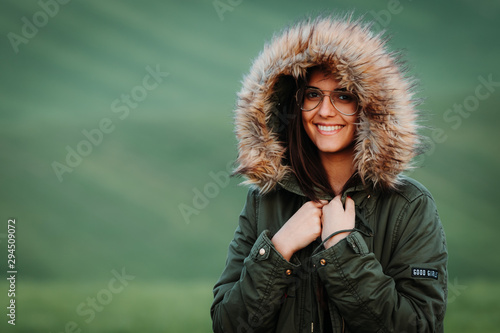 Portrait of a woman feeling cold in winter on green meadow