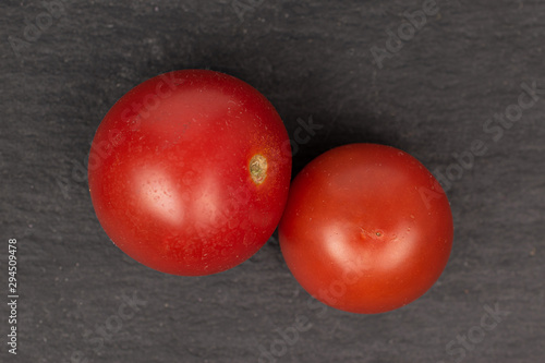 Group of two whole fresh red tomato flatlay on grey stone