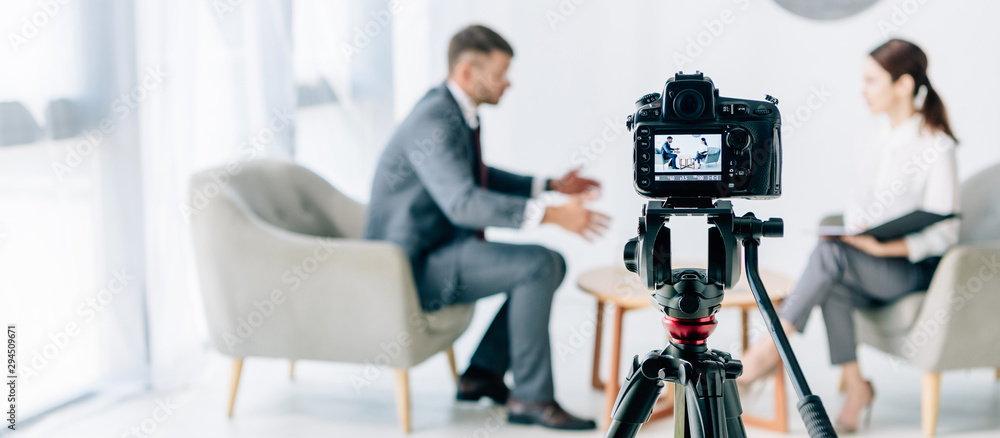 selective focus of digital camera shooting journalist and businessman