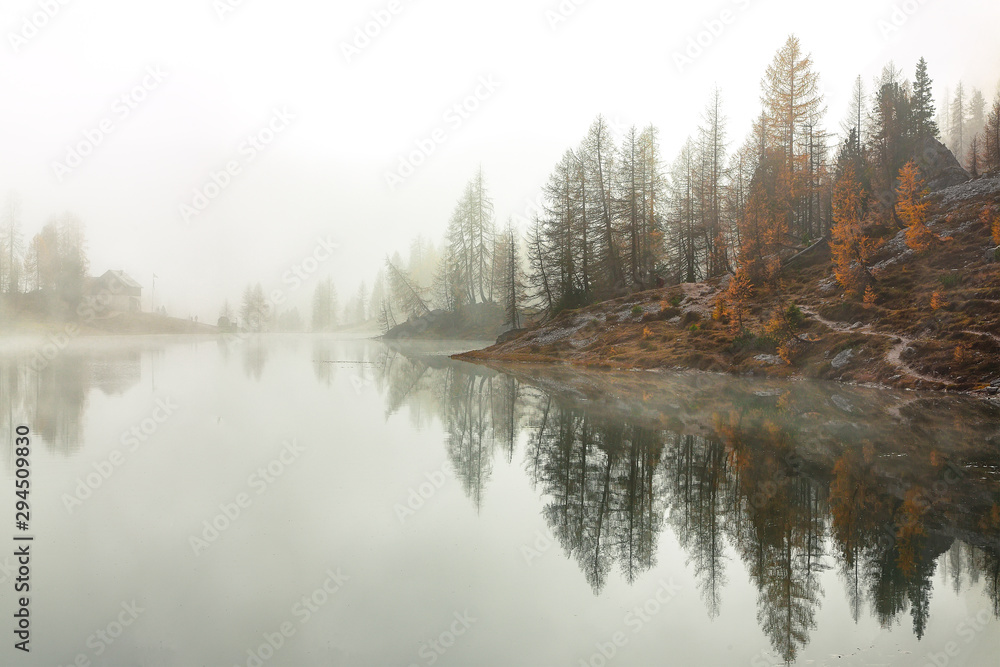 Dramatic foggy autumn landscape. View on Federa Lake early in the morning at autumn