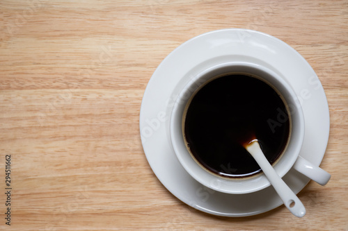 Top view of Black coffee in white cup on wooden background with copy space.