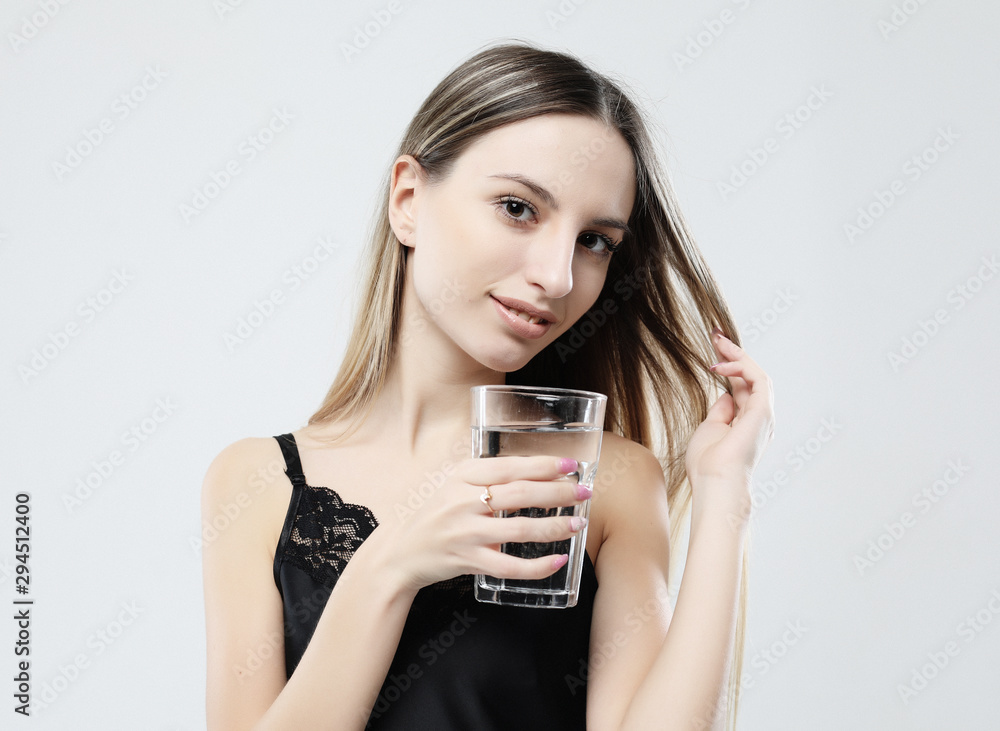 lifestyle, health and people concept - young woman wearing pajamas holding water glass lifestyle, health and people concept - young woman wearing pajamas holding water glass
