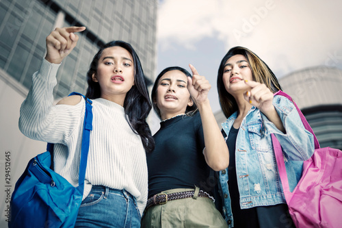 Female teenagers bullying somebody at outdoors