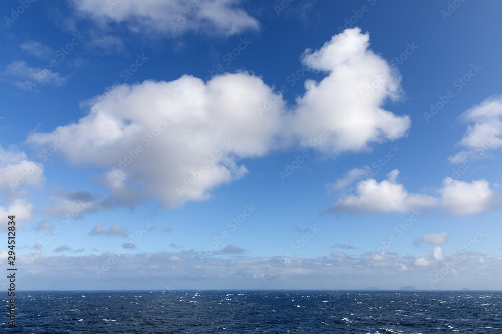 Blauer Himmel mit Wolken über dem Atlantik, mit einer Wolke in der Form eines fliegenden Tieres mit großen Ohren wie einem Hund, Schaf oder einer Kuh.
