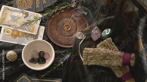 Slow zoom into altar with incense and hands placing crystals into frame