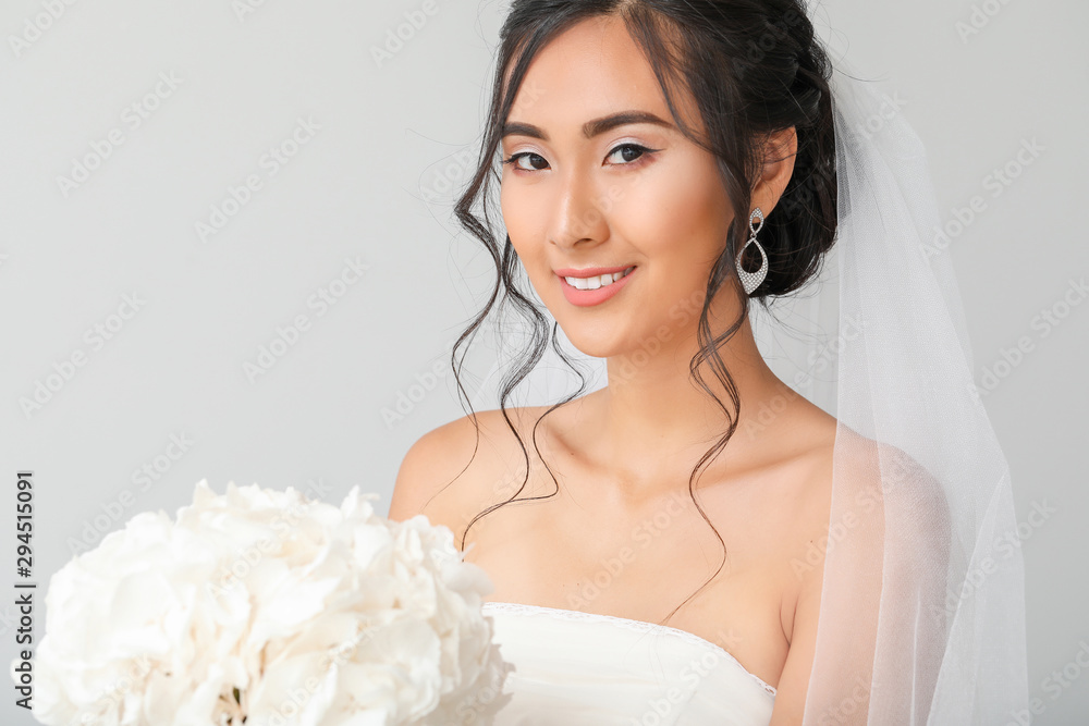 Beautiful young Asian bride on light background Beautiful young Asian bride on light background