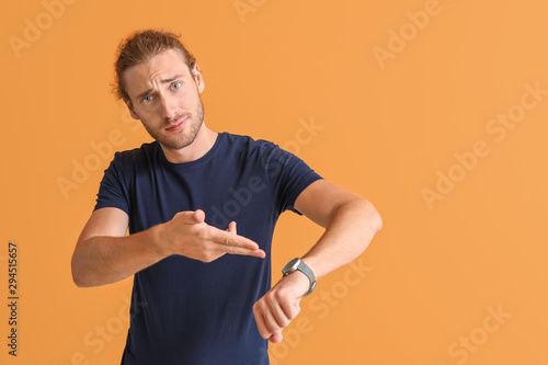 Slika na platnu Stressed man with watch on color background