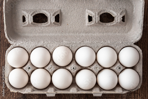 Close up of a dozen eggs in cardboard egg carton, food background
