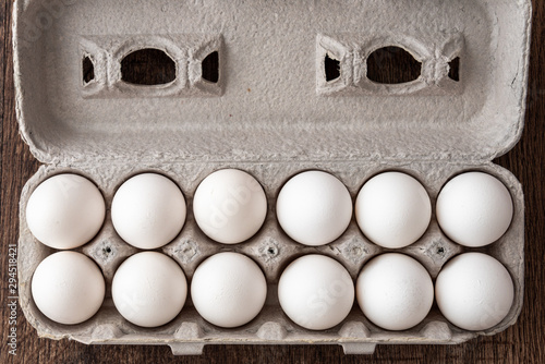 Close up of a dozen eggs in cardboard egg carton, food background photo