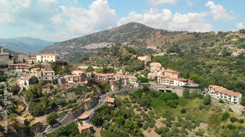 AERIAL DOLLY IN: Drone flying above the old village of Savoca in Sicily Italy, with its picturesque castle and a wonderful view of the mountains photo