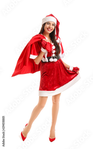 Beautiful young woman in Santa Claus costume holding bag with gifts on white background