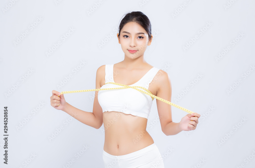 Beautiful portrait asian woman diet and slim with measuring breast and augmentation isolated on white background, girl have cellulite loss with tape measure, health and wellness concept. Beautiful portrait asian woman diet and slim with measuring breast and augmentation isolated on white background, girl have cellulite loss with tape measure, health and wellness concept.