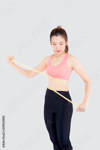Beautiful slim young asian woman measuring tape thin waist wear uniform fitness isolated white background, asia girl loss weight for diet with exercise and workout wellbeing and healthy care body. © N_studio