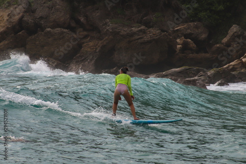 Mujer joven practica surf en costas de Oaxaca Mexico