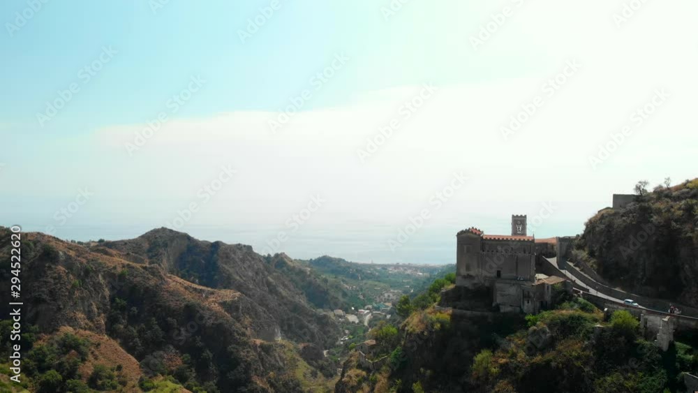 AERIAL: Drone descending above the old village of Savoca in Sicily Italy, with its picturesque castle and a wonderful view over the desolate valley in between mountains AERIAL: Drone descending above the old village of Savoca in Sicily Italy, with its picturesque castle and a wonderful view over the desolate valley in between mountains