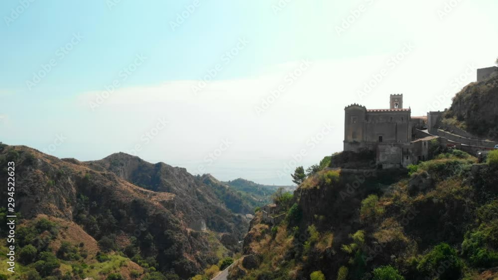AERIAL DOLLY IN: Drone flying above the old village of Savoca in Sicily Italy, with its picturesque castle and a wonderful view over the mountains and the sea AERIAL DOLLY IN: Drone flying above the old village of Savoca in Sicily Italy, with its picturesque castle and a wonderful view over the mountains and the sea