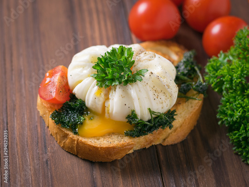Cut poached egg on a piece of fried bread with herbs.