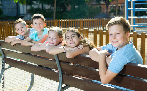 Glad children sitting on a bench