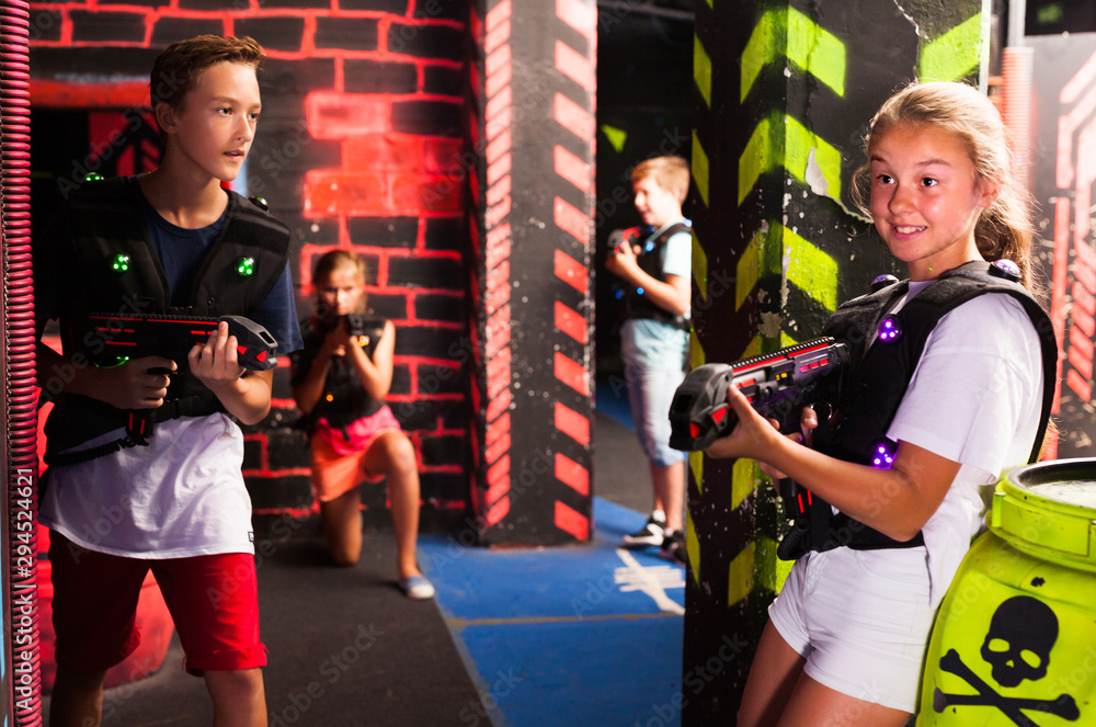 Girls and boys playing laser tag