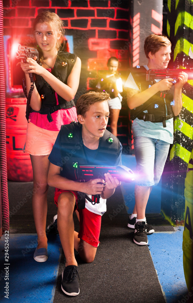 Girls and boys playing laser tag