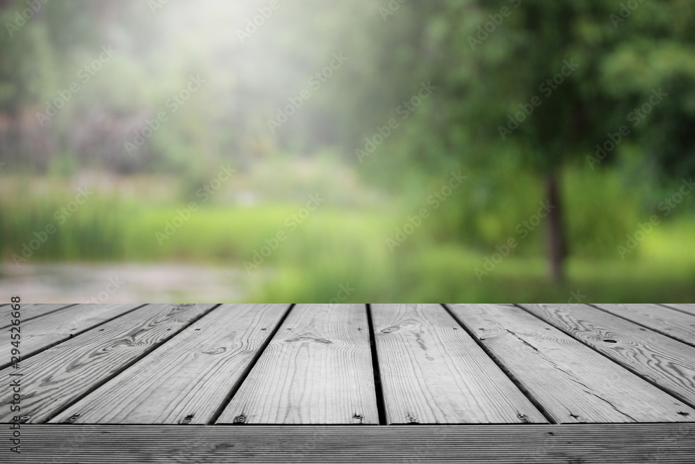 Blurred abstract green bokeh of garden and wooden table background. Blurred abstract green bokeh of garden and wooden table background.