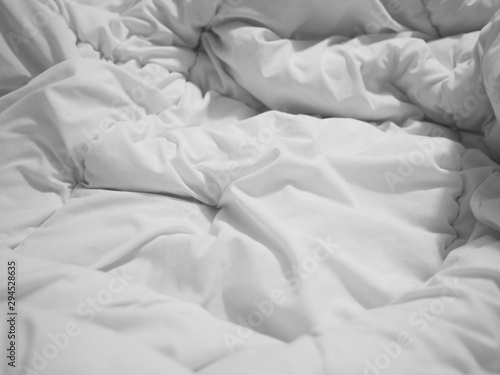 crumpled white bedsheet and blanket surface at bedroom.