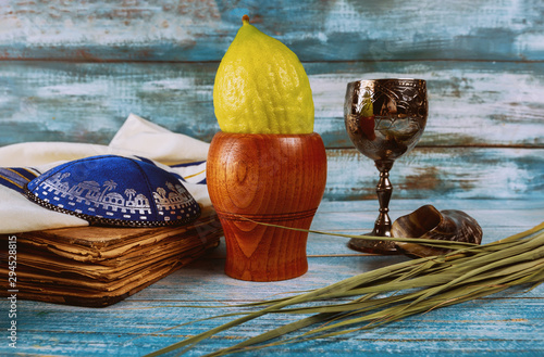 Sukkot Jewish festival of traditional religious symbol Etrog, lulav, hadas, arava kippah tallit praying book photo