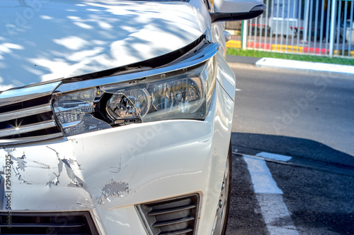 broken headlight of a white passenger car after an accident