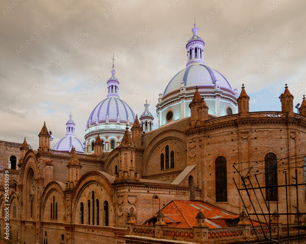 Famous domes of the New Cathedral in Cuenca, Ecuador rise over the city skyline.