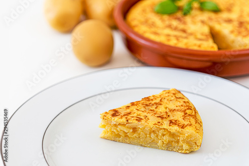 Piece of Omelet with eggs and potatoes isolated on white background. Homemade typical tortilla.