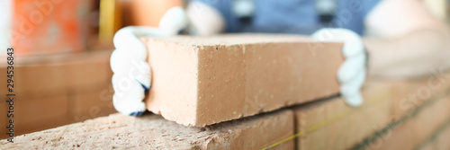 Papier peint Male smiling builder puts make brickwork repair closeup