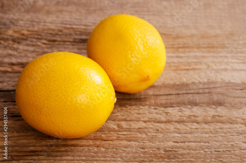 Two lemons on brown wooden table