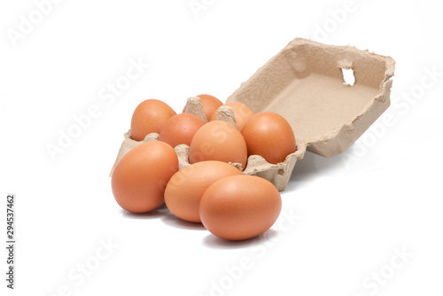 Egg in paper box isolated in white background. Eggs in carton. Green packaging. Chicken eggs from organic farm. Brown cardboard box package. Paper container. Recycled tray packaging. Poultry product. photo