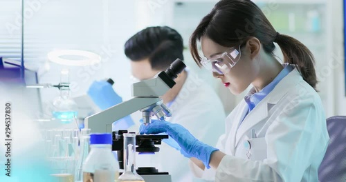 Asian scientist use microscope