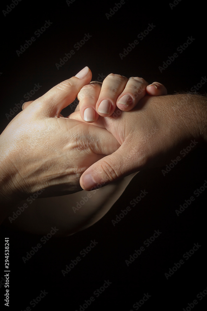 Female hands hold a male hand