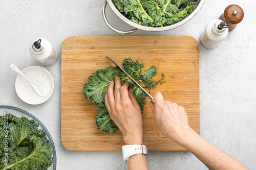 Tableau sur toile Top down view of fresh kale leaves cut on a cutting board