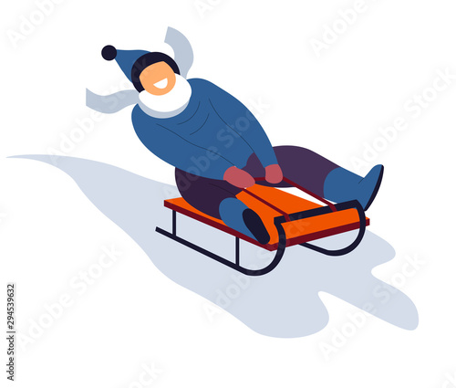 Boy sliding on sled downhill during winter holidays season