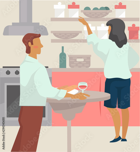 Couple have glass of wine and prepare dinner in kitchen