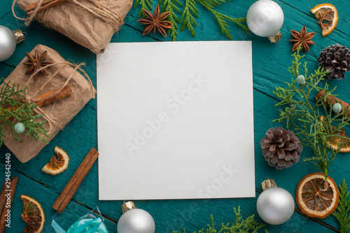 Christmas or New Year composition with gifts, Christmas tree and toys top view with an empty square card, mock up. Christmas mood