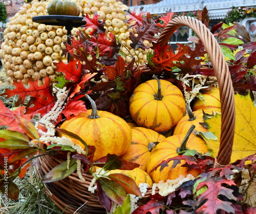 Decorative pumpkins and autumn leaves in a basket. Beautiful autumn still life.