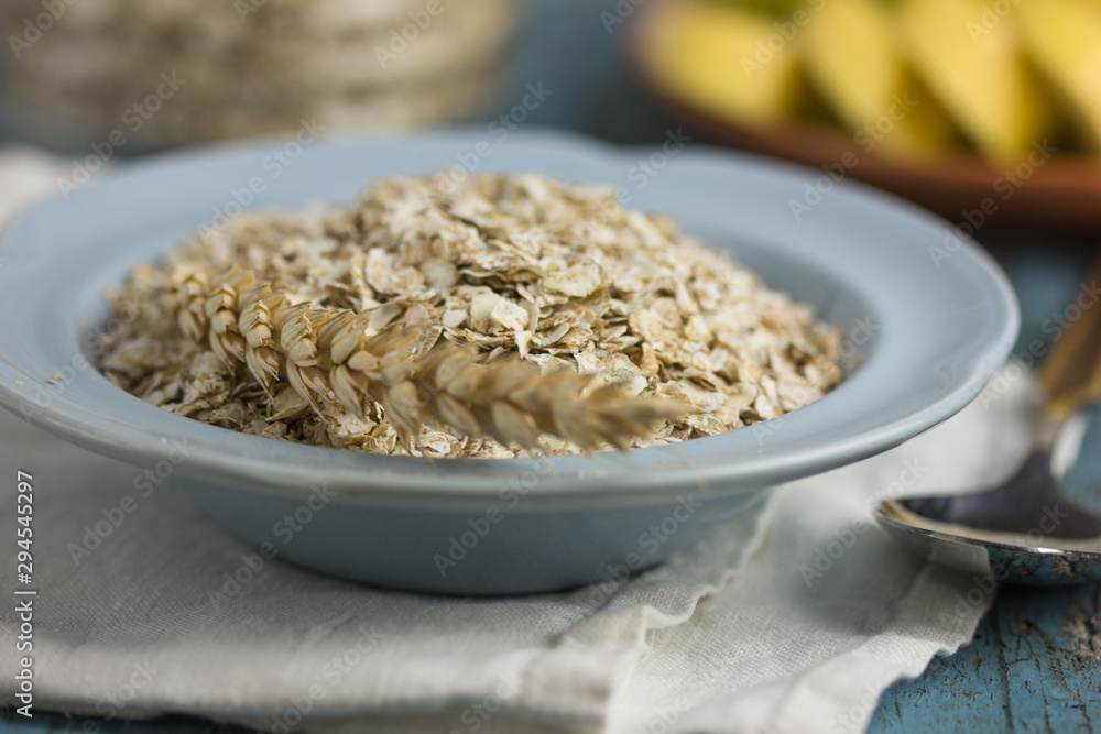 Oat flakes or oatmeal in glass bottle on rustic wood table. Oat flakes or oatmeal in glass bottle on rustic wood table.
