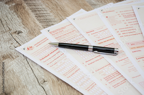Australian tax return and pen on a wooden table. Close-up.
