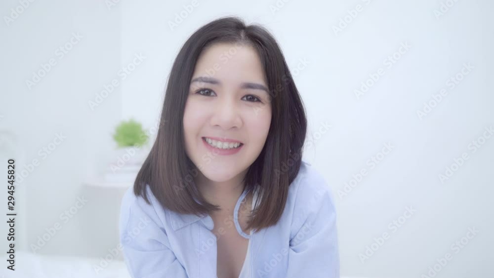 Portrait Asian Chinese woman feeling happy smiling in room at home. Japanese girl relax toothy smile looking to camera while lying bed in bedroom at house in the morning concept. Portrait Asian Chinese woman feeling happy smiling in room at home. Japanese girl relax toothy smile looking to camera while lying bed in bedroom at house in the morning concept.