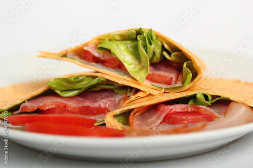 Wrap tortilla sandwich with ham, tomato, lettuce.