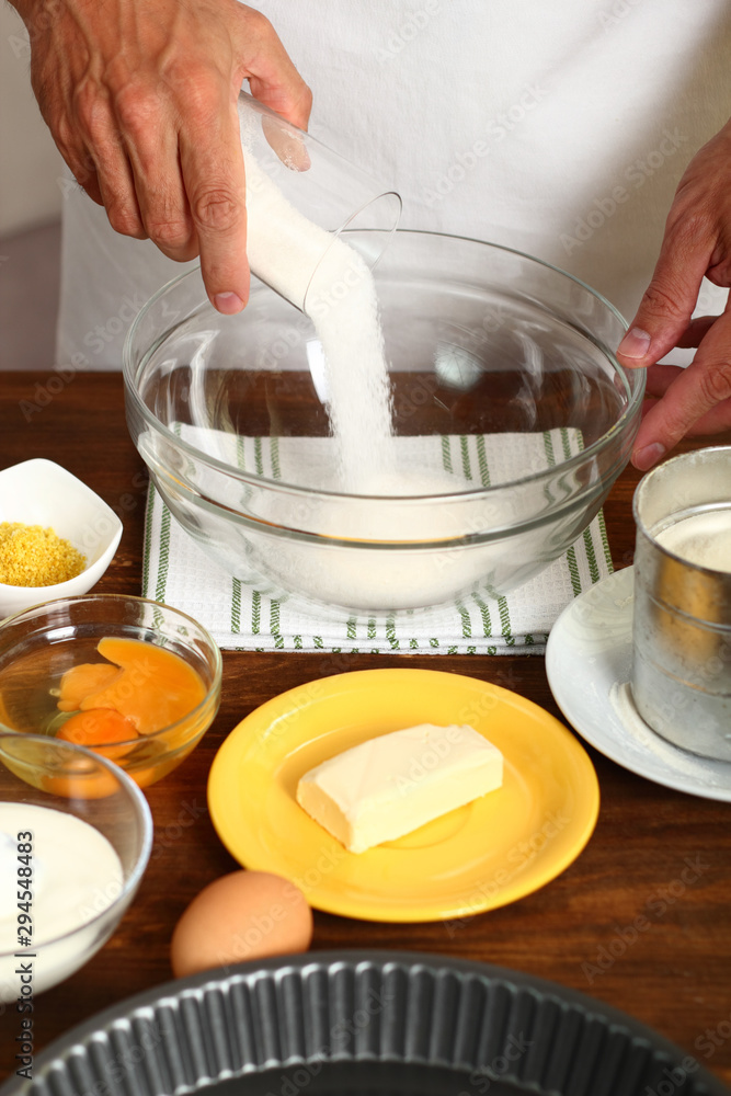 Making Sour Cream Lemon Cake. Pouring sugar into glass bowl. Making Sour Cream Lemon Cake. Pouring sugar into glass bowl.